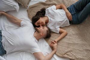 Top view, lying down,. Young couple are together at home photo