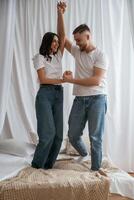 Standing and, playing on the bed... Young couple are together at home photo