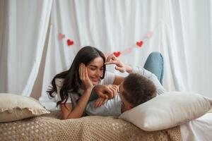Together, on the bed... Young couple are at home photo