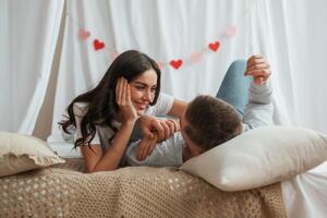 Together, on, th,e bed. Young couple are at home photo