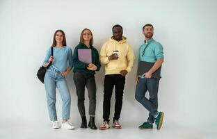 Looking, forward. Group ,of young ,people are standing against white background photo