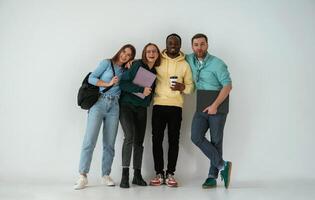 Looking forward. Group ,of, young people, are standing against white background photo