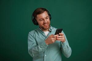 Black smartphone in hands., Man, is standing against background in the studio photo