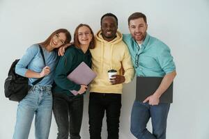 Smiling, looking, forward.. Group of young people are standing against white background photo