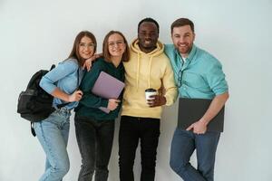 Smiling, looking forward. Group ,of young people are standing against white background photo