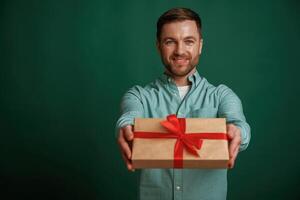 Conception, of ,holidays, with gift box. Man is standing against background in the studio photo
