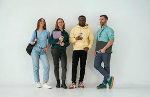 Looking, forward. Group of young people are standing against white background photo