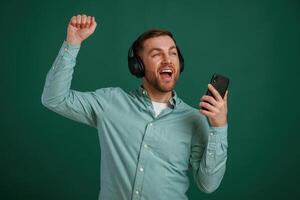Smiling, enjoying ,music.. Man is standing against background in the studio photo