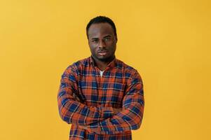 Standing and posing. Black man, is,, in the studio against yellow background photo