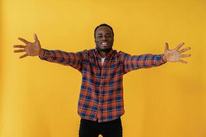Making, hand,, gestures. Black man is in the studio against yellow background photo