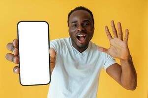 White display of smartphone, for,, copy space. Black man is in the studio against yellow background photo
