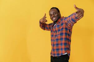 Making, hand ,gestures. Black man is in the studio against yellow background photo