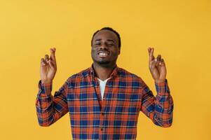 Making hand ,,gestures. Black man is in the studio against yellow background photo
