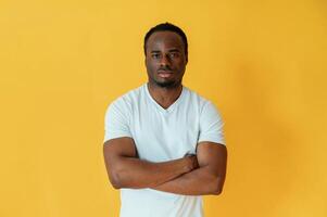Black man ,is in the studio ,against yellow background photo