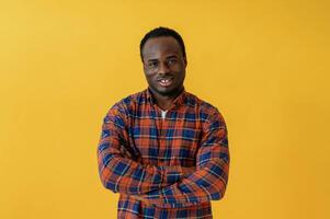 Standing, and ,posing. Black man is in the studio against yellow background photo