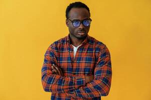 Standing and posing. Black man is in, the studio against yellow background photo