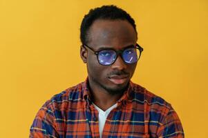 Standing, and posing. Black, man is in the studio against yellow background photo