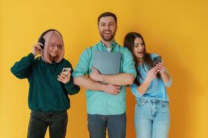 Front view. Group of friends are in the studio against background photo