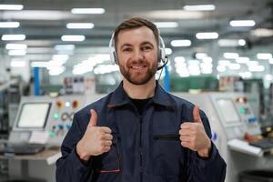 Showing, thumb ,up. Factory ,worker is indoors with hard hat photo