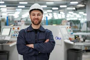 Standing and smiling. Factory worker ,is,, indoors with hard hat photo