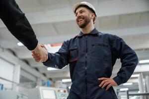 Doing ,handshake. Man on the factory is making deal with other person photo