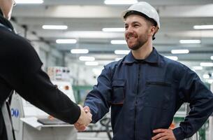 Doing ,handshake. Man ,,on the factory is making deal with other person photo