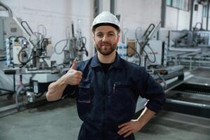 Handsome ,friendly guy. Factory worker, is indoors with hard hat photo
