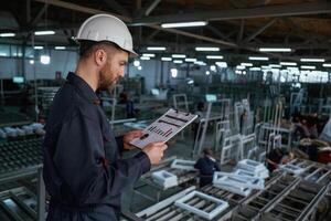 Quality,, control. Factory worker is indoors with hard hat photo
