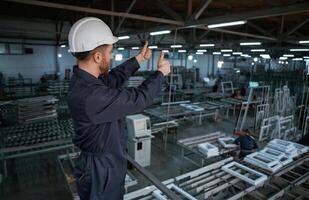 Gesture ,of thumb, up. Factory worker is indoors with hard hat photo