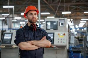 Confident facial ,expression. Factory worker is indoors with hard hat photo