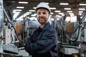 Using equipment, operator., Factory worker is indoors with hard hat photo