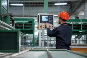 Green colored ,machine,, operator is busy. Factory worker is indoors with hard hat photo