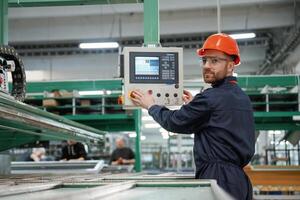 Adjusting ,,settings of machine, operating. Factory worker is indoors with hard hat photo