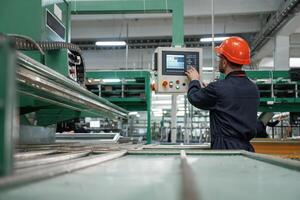 Green ,colored ,machine, operator is busy. Factory worker is indoors with hard hat photo