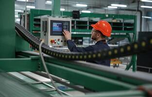 Green,, colored ,machine, operator is busy. Factory worker is indoors with hard hat photo