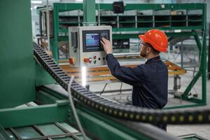 Green colored ,machine, operator, is busy. Factory worker is indoors with hard hat photo