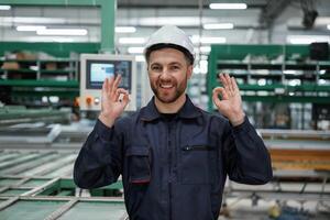 Against,, machine. Factory worker is indoors with hard hat photo
