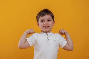 Front,, view. Little boy is in the studio, against yellow background photo