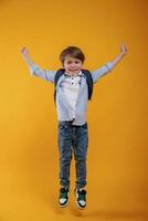 Front, view. Little boy is in the studio against yellow background photo