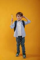 Light bulb ,in hand. Conception of smart person and idea. Little boy is in the studio against yellow background photo
