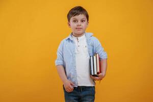 Front view. .Little boy is in the studio against yellow background photo
