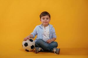 Front ,view. Little boy is in the studio against yellow background photo