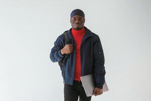 Silver, colored laptop in hand. Black, man in cap is in the studio against white background photo