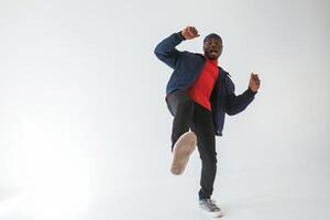 Showing thumbs up, having fun.. Black man in cap is in the studio against white background photo