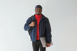 Silver colored laptop in hand. Black man, in, cap is in the studio against white background photo