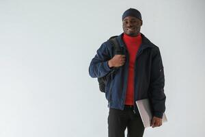 Front view, with laptop. Black man in cap is ,in the studio against white background photo