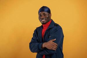 Cheerful facial expression. Handsome black man is in the studio against yellow background photo