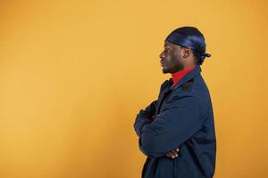 View from, the side. Handsome black man is in the studio against yellow background photo