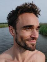Man with beard standing in water outdoors photo