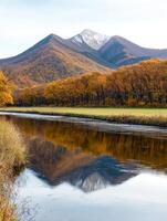 Scenic autumn landscape with mountain reflecting in river photo